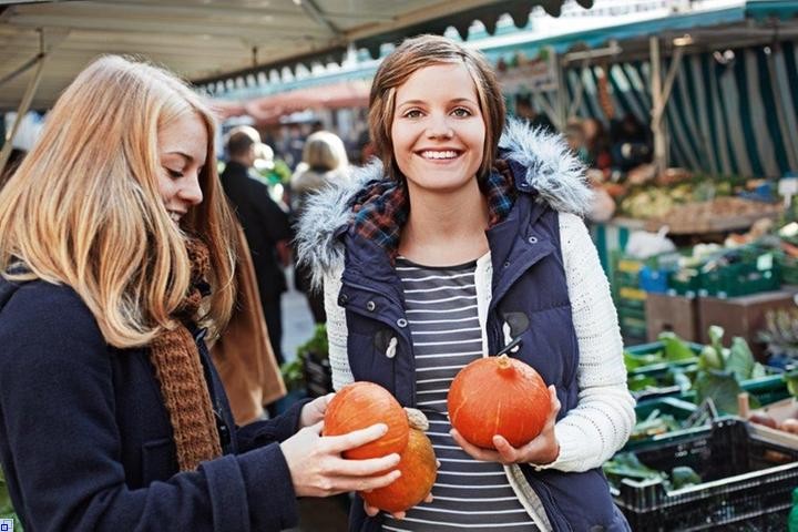 Lächelnde Marktbesucherinnen mit Kürbissen Lächelnde Marktbesucherinnen mit Kürbissen