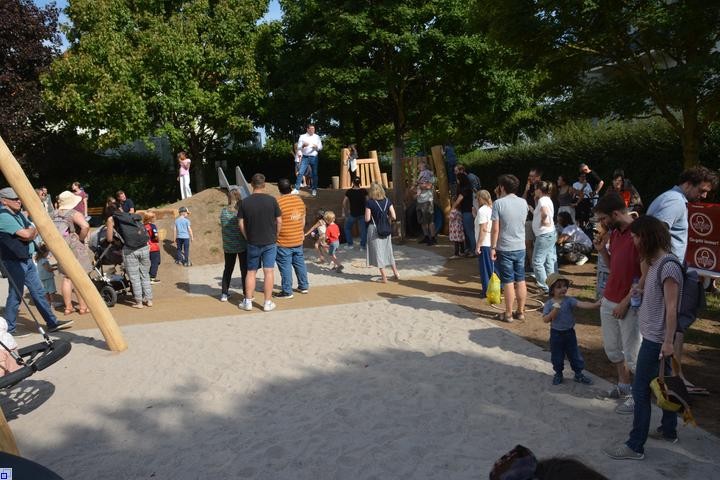 Viele Kinder und erwachsene auf einem Spielplatz