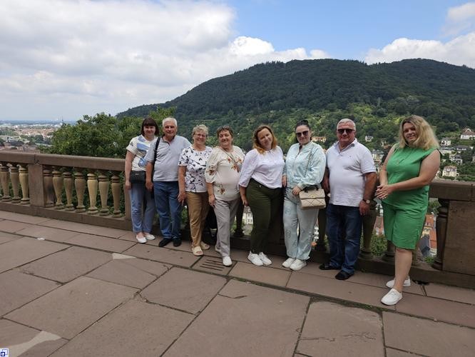 Eine Menschengruppe vor einem Hügel Eine Menschengruppe vor einem Hügel