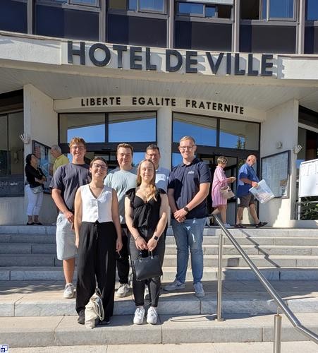 Junge Menschen vor einem Rathaus, das in französischer Sprache  Junge Menschen vor einem Rathaus, das in französischer Sprache