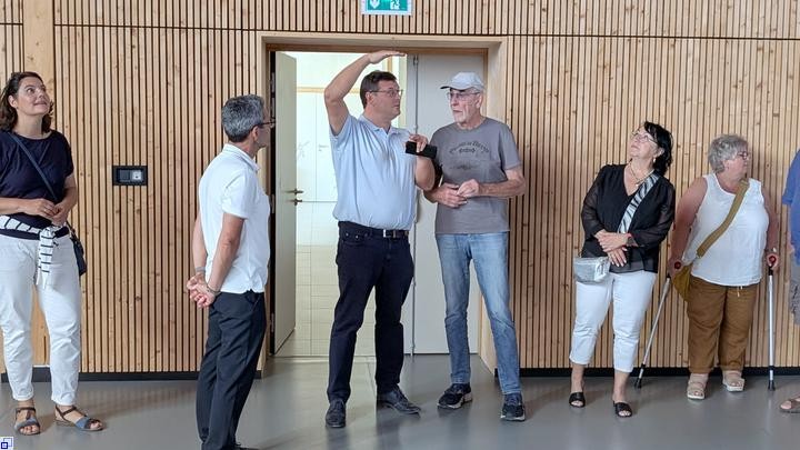 Ein Mann zeigt anderen Zuhörern etwas Ein Mann zeigt anderen Zuhörern etwas