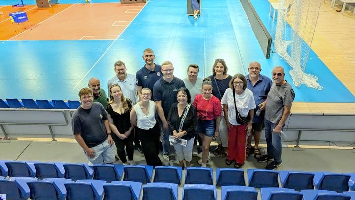 Eine Gruppe Menschen in einer Sporthalle  Eine Gruppe Menschen in einer Sporthalle