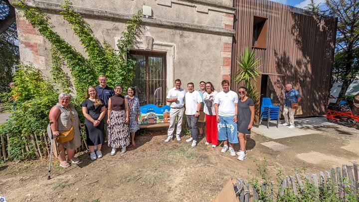 Eine Gruppe Menschen steht an einer farbenfrohen Bank in der Sonne. Eine Gruppe Menschen steht an einer farbenfrohen Bank in der Sonne.