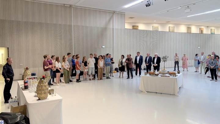 In einem hellen Raum applaudieren festlich gekleidete Menschen In einem hellen Raum applaudieren festlich gekleidete Menschen